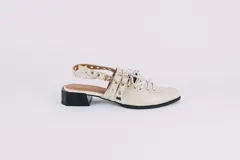 Zapato sueco color hueso de cuero, con cordones, ojales y hebillas. Tiene taco cuadrado negro, tira trasera regulable y elástico para mayor comodidad.