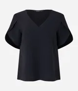 Blusa color beige con escote en pico y mangas cortas tulipán. Confeccionada en tejido de poliéster con efecto airflow (textura arrugada).