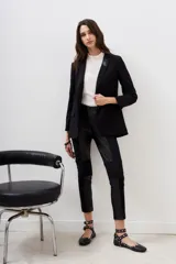 Pantalón negro de corte recto, con paneles de cuero sintético en los laterales y rodillas acolchadas.