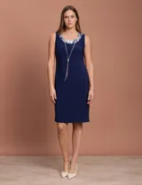 Conjunto de vestido azul marino con chaqueta estampada con motivos florales en tonos plateados y azules.