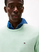 Sweater de cuello redondo color verde claro, confeccionado en algodón. Presenta logo bordado en el pecho, cuello, puños y bajo de punto canalé. Corte regular y hombros ligeramente caídos.