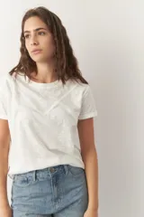 Remera de algodón blanca, de manga corta y cuello redondo, con corte clásico.