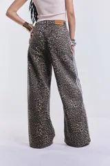Pantalón de jean de corte ancho con estampado animal print y rayas blancas laterales.