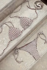 Conjunto de bikini azul con corpiño de triángulos movibles con almohadillas desmontables, que se ata al cuello y a la espalda. La bombacha es vedetina con tiritas a los costados para atar a medida de la cadera.