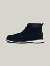 Botines Tommy Hilfiger de hombre, color azul marino, confeccionados en ante con interior de poliéster y suela de goma. Presentan cordones, logo Hilfiger en el tobillo y detalle distintivo en el talón.