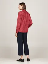 Blusa de manga larga color rojo con cuello inglés y lazo, presenta un sutil estampado de rombos con logo en tono tonal.