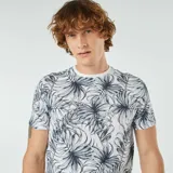 Remera blanca con estampado de hojas de palmera en tonos verde y azul.