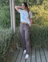 Pantalón de lino marrón con rayas verticales blancas, corte recto, cintura con elástico ancho y cinturón de rafia extraíble.
