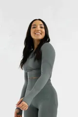 Remera gris de calce ajustado, con mangas largas y orificios para los pulgares.