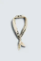 Pañuelo bandana color crema con estampado paisley en negro.