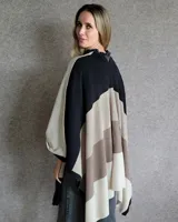 Ruana de lana gris y negro, con diseño geométrico y corte amplio.