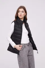 Chaleco negro sin mangas, acolchado y ajustado al cuerpo, ideal para combinar con otras prendas.