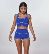 Conjunto deportivo azul eléctrico con costuras blancas. Incluye top deportivo con logo 'bk.' y shorts de tiro alto.