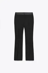 Pantalón negro de tiro alto con corte flare y cinturilla combinada a tono. Presenta bolsillos laterales y falsos bolsillos de vivo en la espalda.