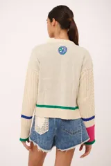 Sweater azul marino de punto con cuello redondo y mangas largas con diseño trenzado. Presenta un estampado de frutas y verduras con la inscripción "La verdulería S.A.".