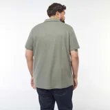 Remera polo de piqué color verde oliva, de corte clásico y manga corta.