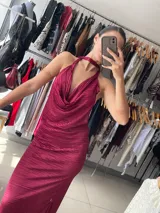 Vestido largo color borgoña con textura plisada, escote halter con cuello choker y espalda descubierta.