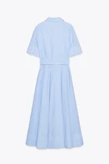 Vestido camisero midi de popelín a rayas verticales celestes y blancas, con cuello solapa, manga corta, bolsillos de plastrón con solapa en el pecho, cinturón de lazo ajustable y cierre frontal con botones.