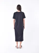 Vestido negro de corte recto, largo midi y mangas cortas.