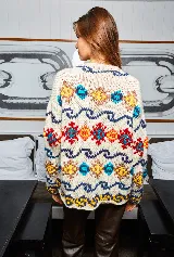 Sweater de lana tejido a mano en Uruguay, de calce holgado, con cuello a la base y puños ajustados. Diseño con motivos geométricos en colores azul, amarillo, rojo y blanco.