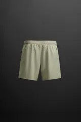 Shorts de entrenamiento negros confeccionados en tejido técnico ligero y elástico, con cintura elástica ajustable con cordón interior, bolsillos frontales y bolsillo trasero con cierre de cremallera. Bajo con acabado termofijado y aberturas laterales.