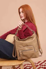 Cartera mochila color tostado, símil cuero, con compartimiento principal amplio y bolsillos frontales con cierre. Tiene correas ajustables para usar como mochila y asa superior para llevar al hombro.