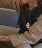 Collar con cadena fina negra y dije de estrella plateada con incrustaciones de strass.