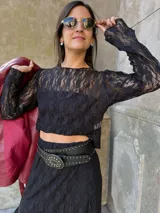 Remera de encaje negro con mangas largas, cuello redondo y corte ajustado.