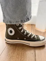 Zapatillas de lona blancas de caña alta con cordones y puntera de goma. Logo de durazno engomado en la base y en la cara interna.