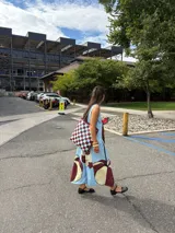 Bolso tipo tote de cuero tejido a mano con diseño a cuadros en color negro y tostado.