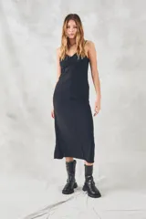 Vestido negro de corte ajustado con tirantes finos, confeccionado en viscosa, con abertura frontal y diseño fluido.