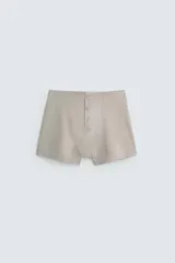 Conjunto de pijama color gris compuesto por una camiseta sin mangas de corte ajustado y un bóxer corto con cintura elástica y botones.