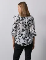 Blusa de gasa estampada con flores, marca Zac & Rachel. Tiene cuello a la base, escote en V y abertura con botones. Las mangas largas son de largo regulable.