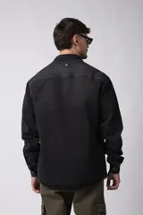 Chaqueta de jean celeste de corte recto, con cuello clásico, cierre frontal con botones metálicos y bolsillo de parche en el pecho.