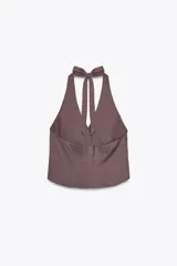 Chaleco marrón con cuello halter ajustable con lazada y escote pico. Cierre frontal con botones.