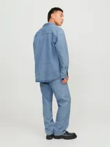 Sobrecamisa de jean celeste con manga larga, cuello clásico, cierre con botones y bolsillo frontal.