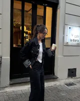 Campera corta de jean azul oscuro con cuello clásico, cierre con botones metálicos y bolsillos frontales.