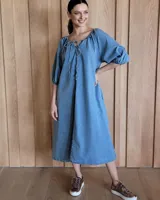Vestido midi celeste de denim, con escote con lazo, mangas 3/4 abullonadas y corte evasé.