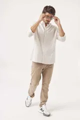 Camisa de lino color blanco, de corte regular, con cuello clásico y mangas largas.