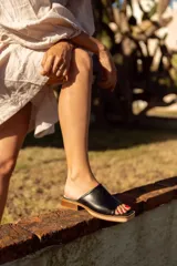 Sandalias doradas de cuero con base cuadrada y taco bajo.