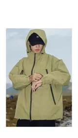Campera impermeable de color verde pistacho, con capucha ajustable, cierres negros en el frente y bolsillos, y velcro regulador en los puños.