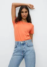 Camiseta de algodón color naranja con logo Mango estampado en el pecho. Diseño recto, cuello redondo y manga corta.