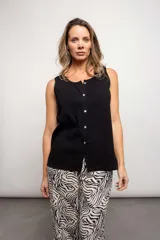 Musculosa lila con cuello redondo, sin mangas y abotonada al frente. Detalle de puntilla en el ruedo.