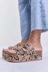 Sandalias con plataforma de corcho, con estampado animal print en tonos beige y negro, y hebillas metálicas plateadas.