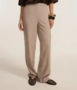 Pantalón de vestir color beige, de corte recto, confeccionado en crepé. Cuenta con cintura fija, bolsillos laterales tipo cuchillo y cierre frontal oculto.