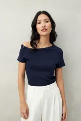 Top tejido azul marino de silueta ajustada con diseño minimalista y escote asimétrico, adornado con pequeños botones metálicos.