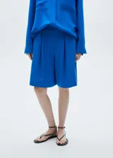 Short azul eléctrico de lyocell y lino con diseño wideleg, trabillas, cierre delantero de botón, gancho y cremallera, detalle de pinzas y tiro alto.