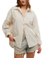 Camisa a rayas verticales color crema y marrón, de corte oversize y estilo masculino. Tiene cuello camisero, cierre frontal con botones y canesú en la espalda.