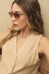 Chaleco color crema con bordado de hojas en marrón, con cuello en V y cierre frontal con botones.