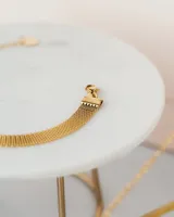 Pulsera dorada de acero quirúrgico con eslabones tipo malla y cadena de extensión.